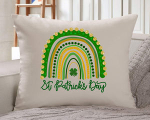 white pillow mock up with St Paddys Rainbow on it with blanket in the background