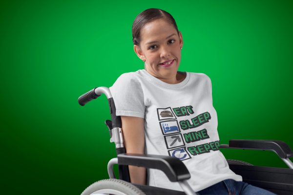 dark green to light green background with lady sitting in a wheelchair with white tshirt on with eat sleep mine repeat on the shirt